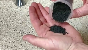 Person pouring biosolids from container into hand