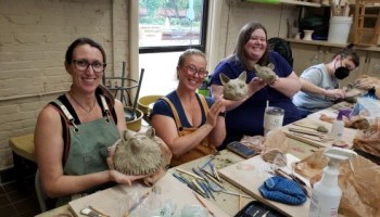students showing off their animal head sculpture (workshop)
