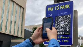 New pay to park QR code signage being used by a mobile device. 