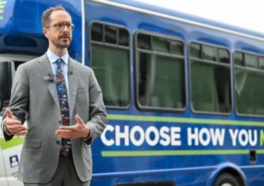 Mayor in front of Choose How You Move bus