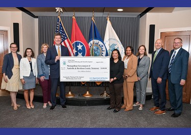 Mayor's office staff and others at a check presentation