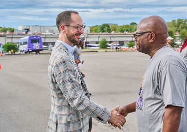 Mayor Freddie O'Connell shakes hands with a person in front of a WeGo bus