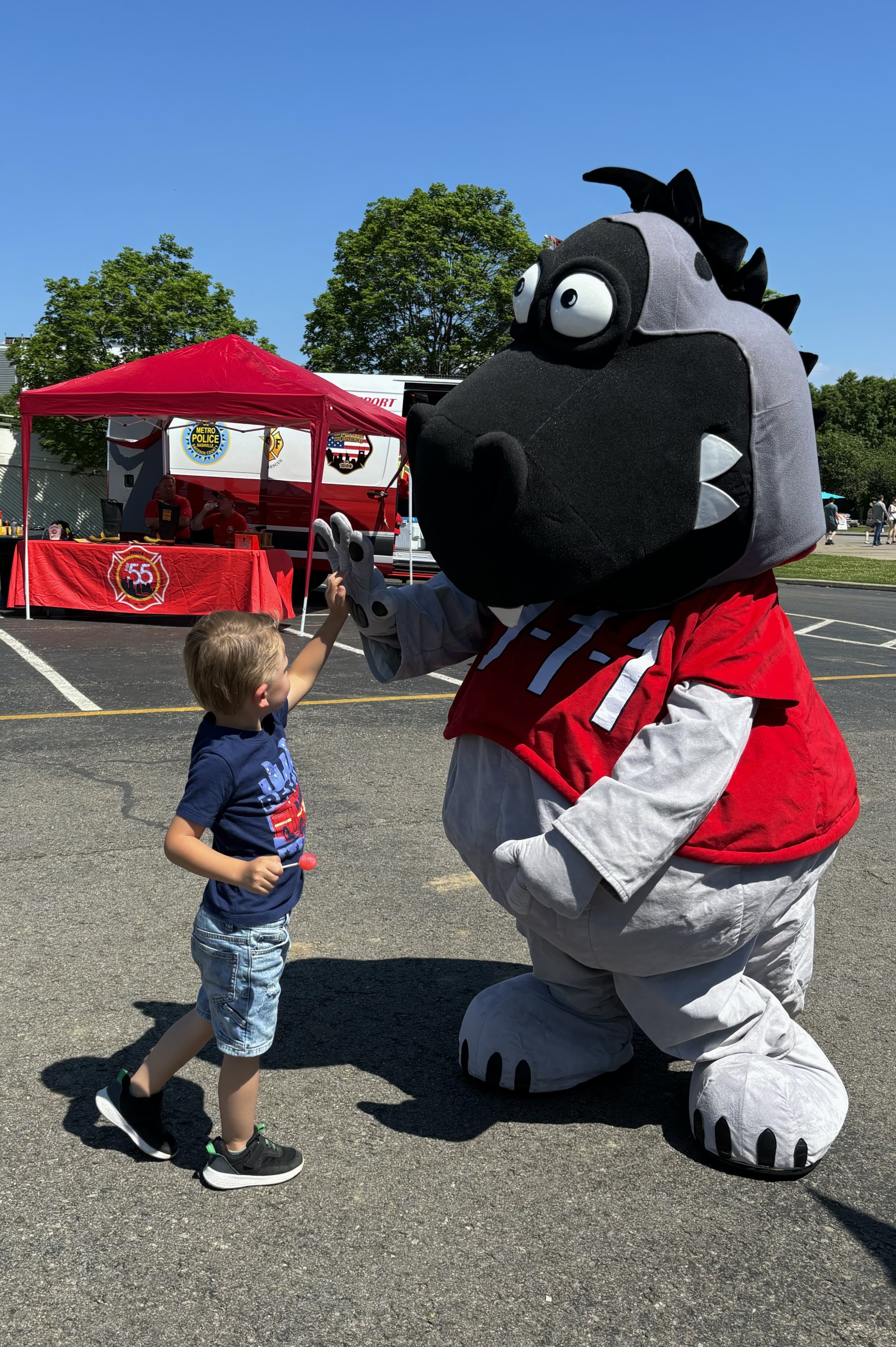 boy with a person in a dinosaur costume.