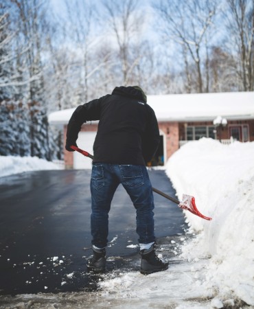 Man shoveling snow off driveway
