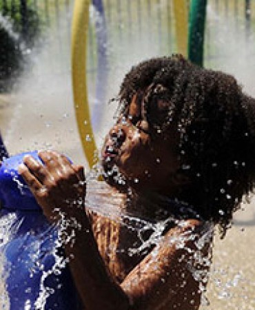 child playing in water toy at sprayground