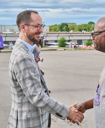 Mayor Freddie O'Connell shakes hands with a person in front of a WeGo bus