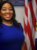 Woman standing next to a flag.